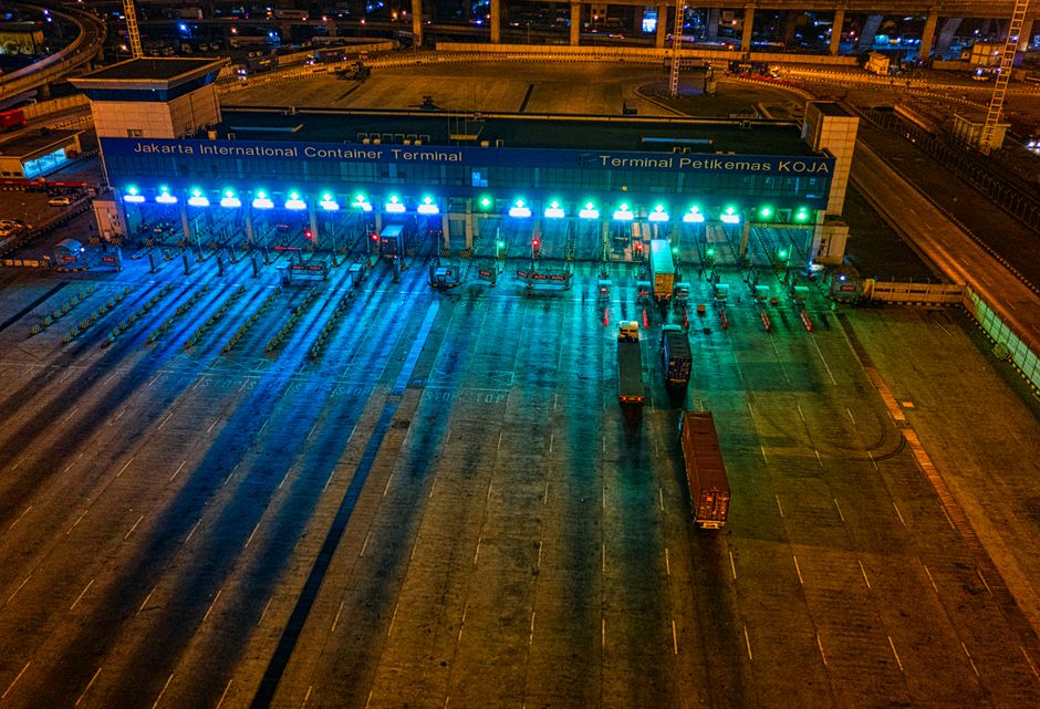 Illuminated aerial view of Jakarta International Container Terminal highlighting logistics activity at night.